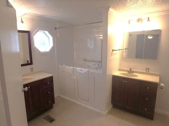 bathroom with a sink, visible vents, two vanities, and a textured ceiling