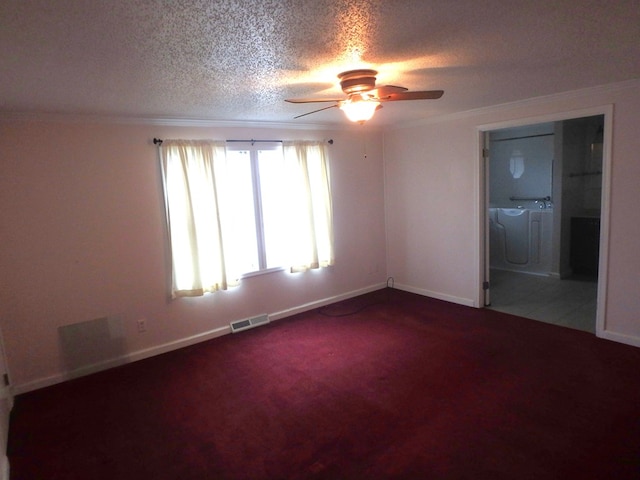 spare room with visible vents, ornamental molding, carpet, a textured ceiling, and washer and dryer