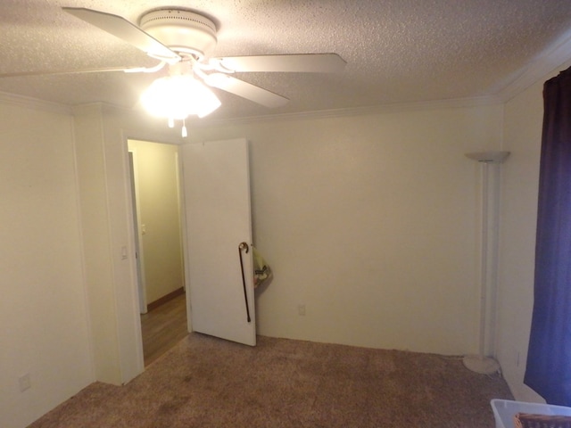 unfurnished room with a textured ceiling, ceiling fan, carpet, and crown molding