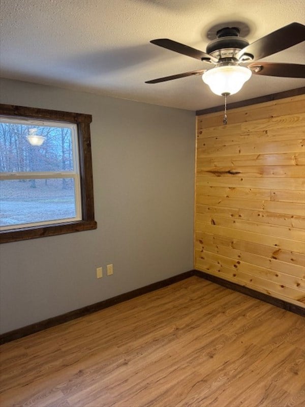 unfurnished room featuring a textured ceiling, light hardwood / wood-style flooring, and ceiling fan