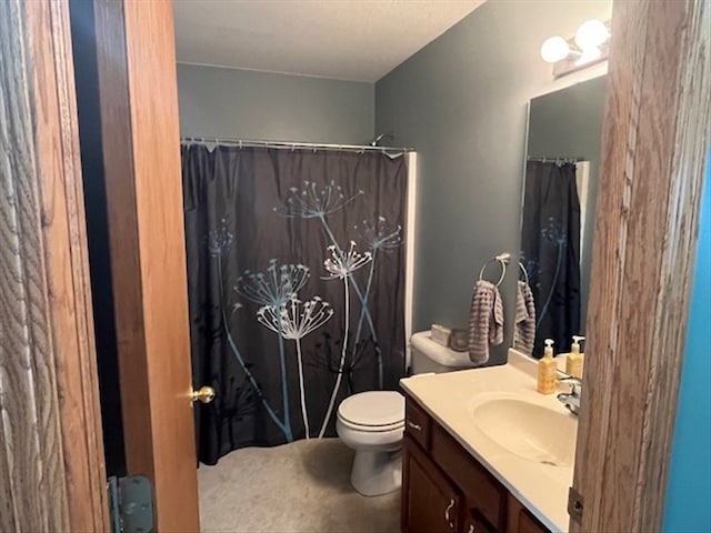 bathroom featuring a shower with shower curtain, vanity, and toilet