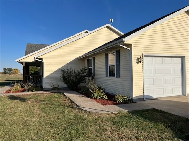 view of side of home with a lawn and a garage