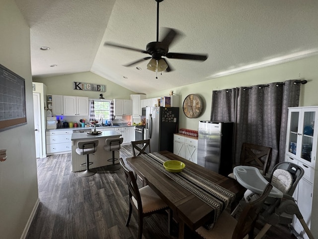 1203 E Randolph St, Kirksville, MO 63501 - dining space featuring vaulted ceiling, dark wood-style flooring, ceiling fan, and a textured ceiling
