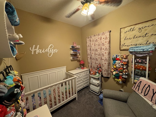 1203 E Randolph St, Kirksville, MO 63501 - bedroom featuring dark carpet, a ceiling fan, and a nursery area