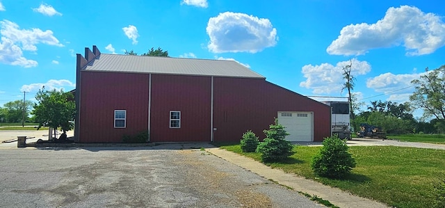 100 Pleasant St, Cincinnati, IA 52549 - view of side of home featuring a detached garage, a yard, an outdoor structure, driveway, and a metal roof