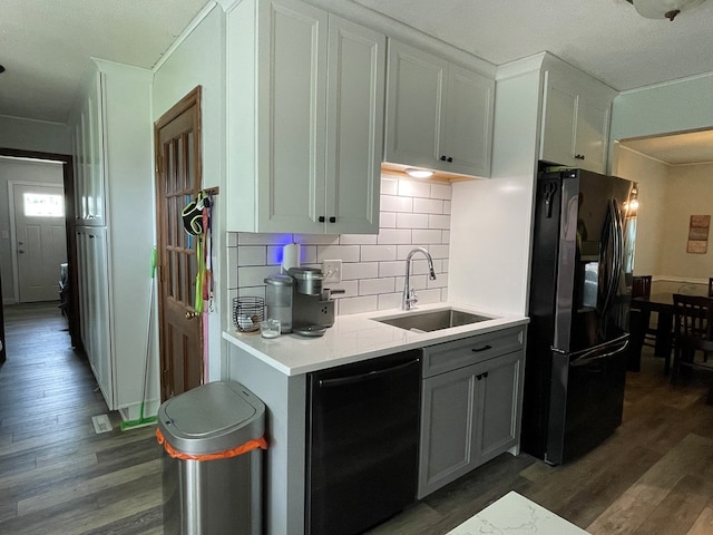 820 Fairlane Dr, Chillicothe, MO 64601 - kitchen with black appliances, a sink, dark wood-type flooring, backsplash, and light countertops