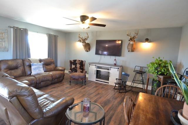 living room with dark wood-type flooring, a fireplace, and ceiling fan