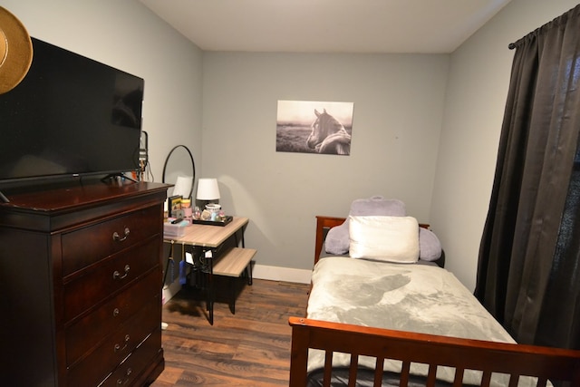 bedroom with dark hardwood / wood-style flooring