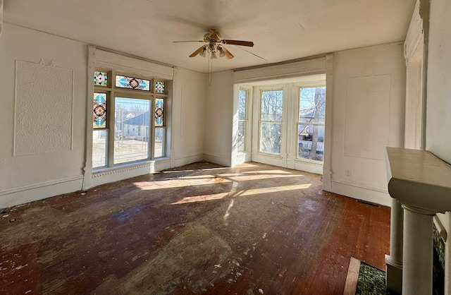 unfurnished living room with ceiling fan and wood finished floors