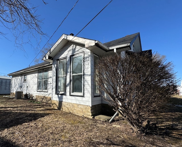 view of side of home with an outbuilding, a shed, and central AC