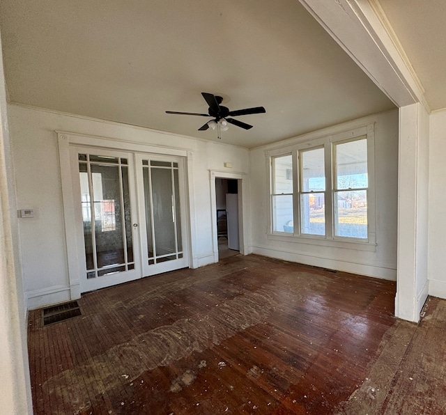 unfurnished living room featuring visible vents, crown molding, a ceiling fan, and wood-type flooring