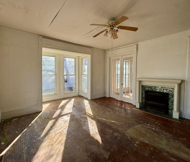 unfurnished living room featuring a textured ceiling, a ceiling fan, and a tile fireplace