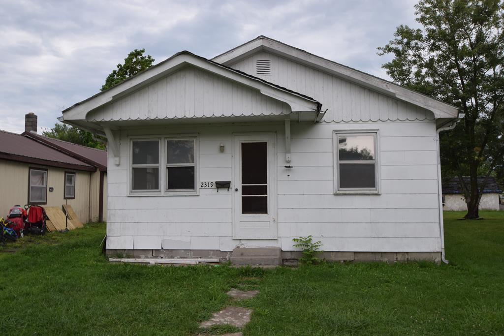 rear view of property with a yard