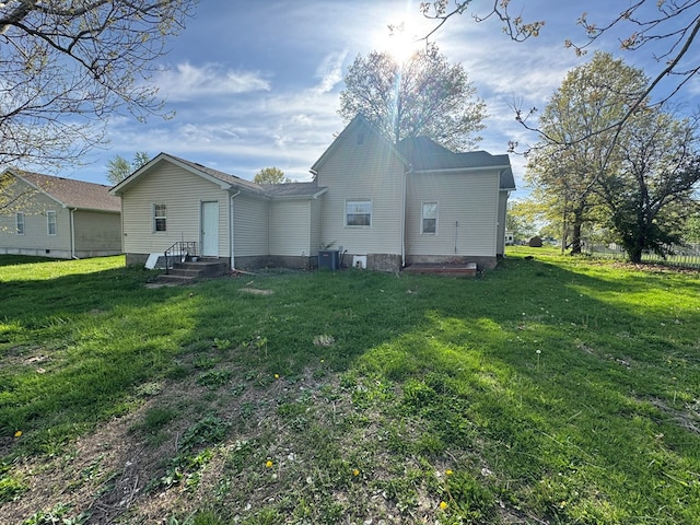 back of property featuring a yard and cooling unit