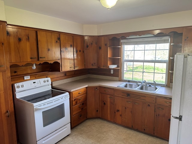 kitchen with brown cabinets, open shelves, a sink, white appliances, and light countertops