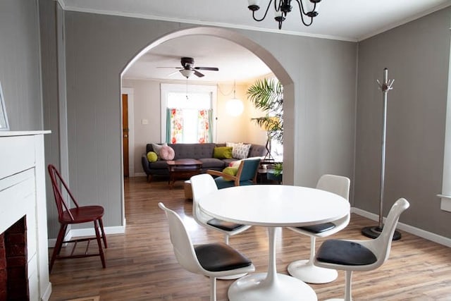 dining room featuring hardwood / wood-style flooring, ceiling fan with notable chandelier, and ornamental molding