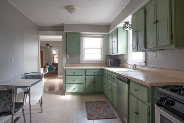 kitchen featuring ceiling fan, dishwasher, sink, black range with gas stovetop, and green cabinetry