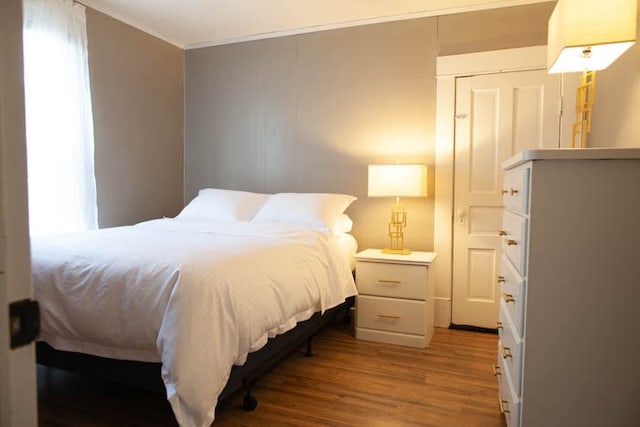 bedroom featuring wood-type flooring and crown molding