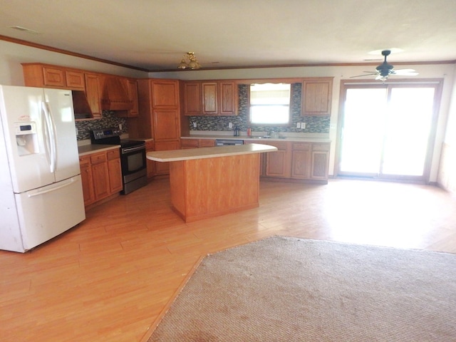 kitchen with crown molding, white fridge with ice dispenser, light hardwood / wood-style floors, a kitchen island, and black / electric stove