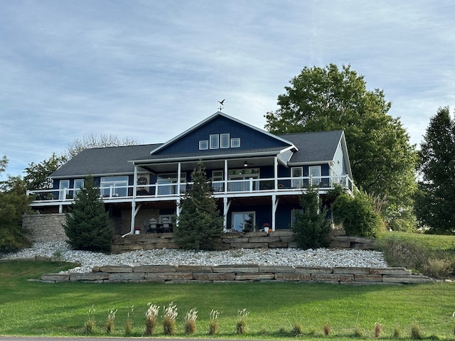 back of house featuring ceiling fan and a yard