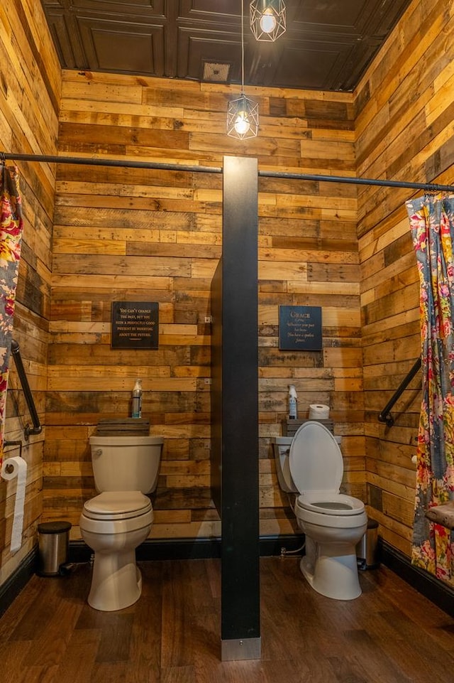 bathroom featuring wood-type flooring, toilet, and wooden walls