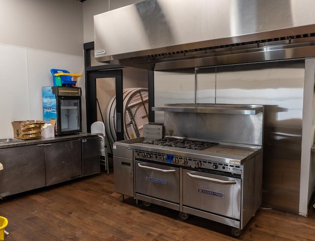 kitchen with dark wood-type flooring, wall chimney range hood, and dark brown cabinetry