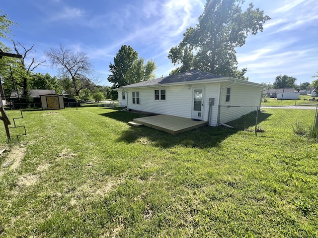 rear view of house featuring a storage shed, a deck, and an outbuilding