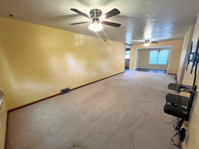 unfurnished living room with a ceiling fan, carpet floors, and baseboards