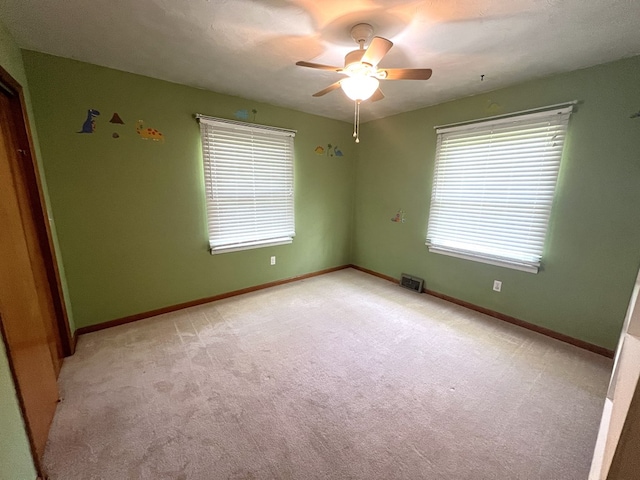unfurnished bedroom featuring light colored carpet, baseboards, and a ceiling fan