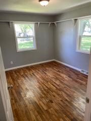 unfurnished bedroom featuring wood finished floors and baseboards