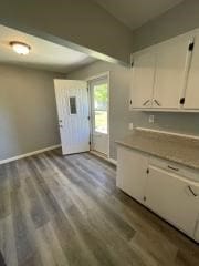kitchen featuring white cabinets, dark wood-type flooring, and baseboards
