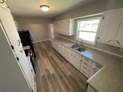 kitchen with a sink, dark wood-style flooring, and white cabinetry