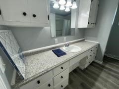 full bath featuring wood finished floors, baseboards, vanity, and a chandelier