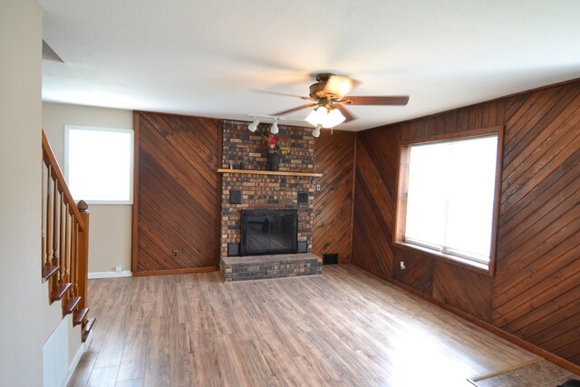 1415 E Patterson St, Kirksville, MO 63501 - unfurnished living room featuring a ceiling fan, wood walls, stairway, wood finished floors, and rail lighting