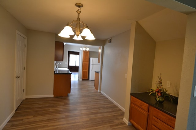 1415 E Patterson St, Kirksville, MO 63501 - kitchen with a chandelier, freestanding refrigerator, wood finished floors, dark countertops, and brown cabinetry
