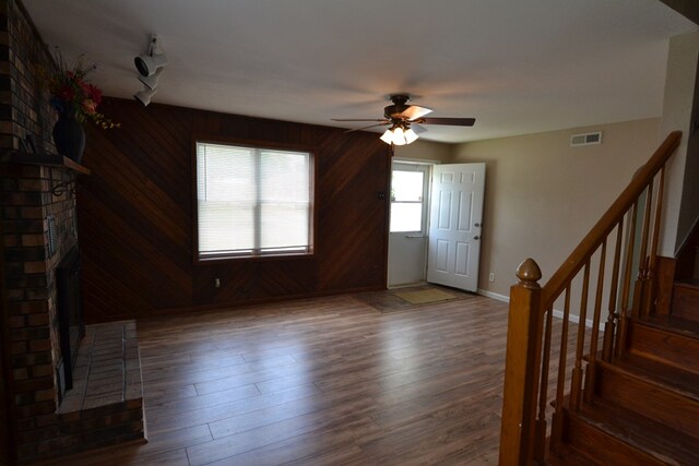 1415 E Patterson St, Kirksville, MO 63501 - foyer featuring a brick fireplace, a ceiling fan, stairway, wood finished floors, and wood walls