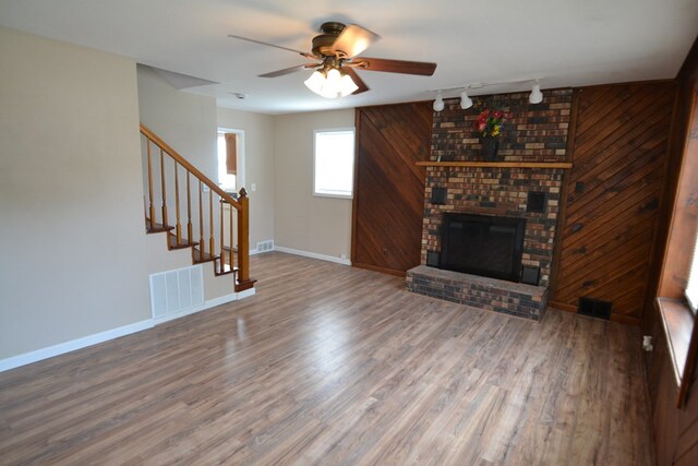 1415 E Patterson St, Kirksville, MO 63501 - unfurnished living room featuring track lighting, a ceiling fan, wood finished floors, stairway, and a brick fireplace