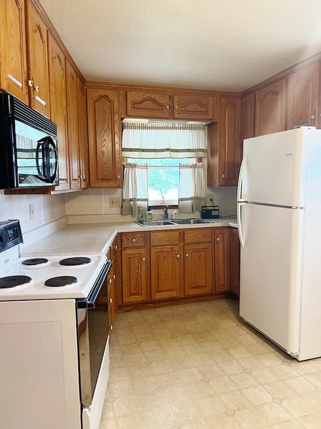 904 E George St, Kirksville, MO 63501 - kitchen with white appliances, brown cabinetry, decorative backsplash, light countertops, and light floors