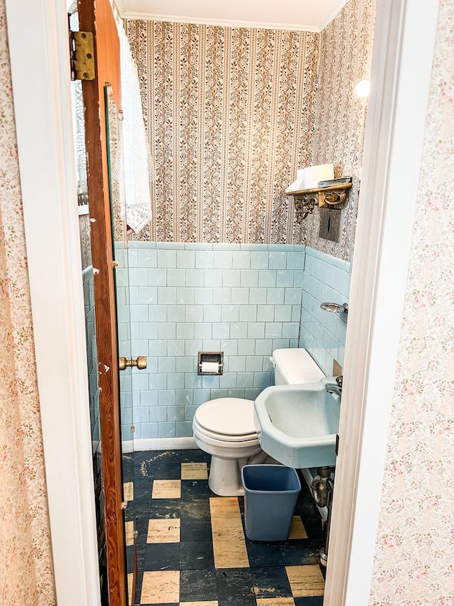 bathroom featuring tile walls, sink, ornamental molding, and toilet