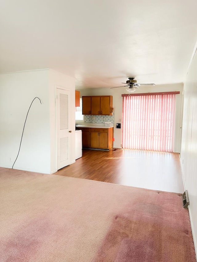 unfurnished living room with ceiling fan and light colored carpet