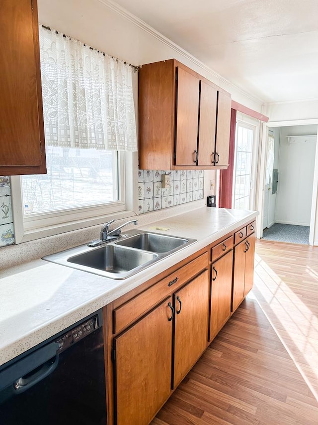 kitchen with sink, crown molding, dishwasher, and light wood-type flooring