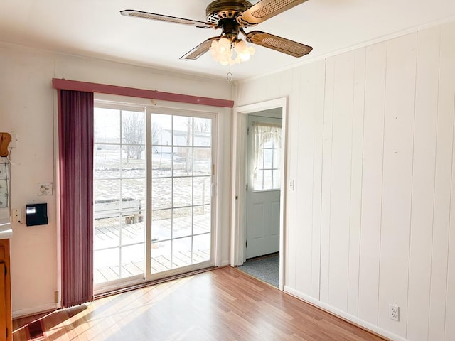 entryway featuring ceiling fan, hardwood / wood-style flooring, ornamental molding, and a healthy amount of sunlight