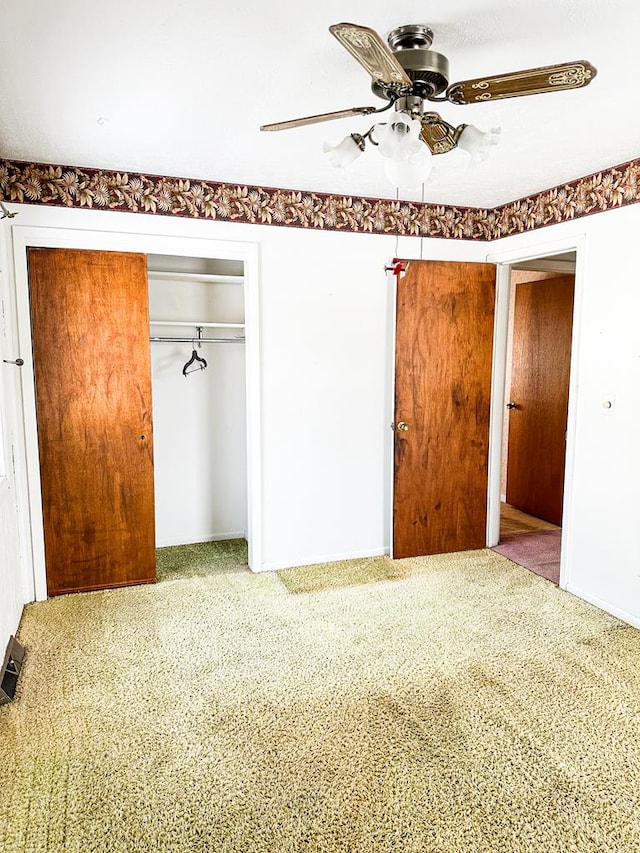 unfurnished bedroom featuring carpet, ceiling fan, and a closet