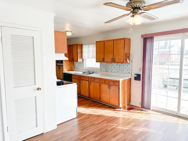 kitchen featuring white electric stove, sink, decorative backsplash, light hardwood / wood-style floors, and ceiling fan