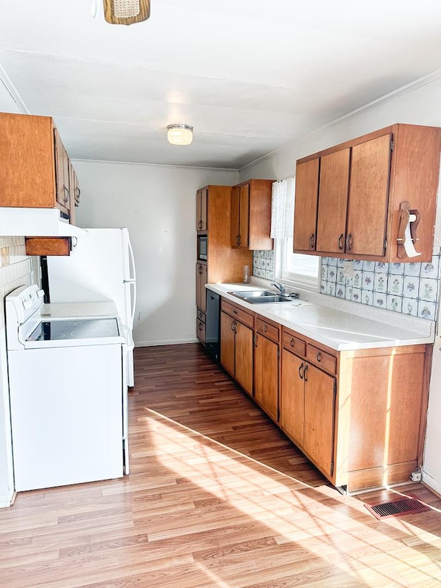 kitchen with light wood-type flooring, sink, decorative backsplash, and electric range