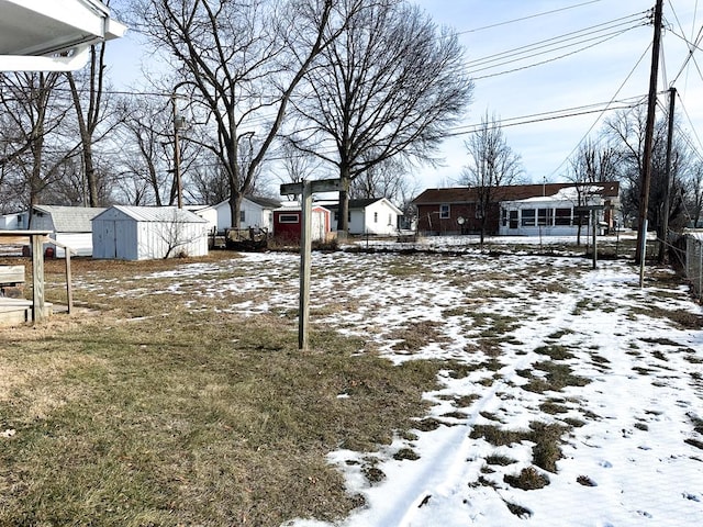 yard layered in snow with a shed