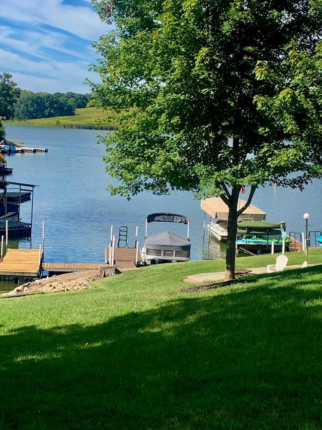 dock area with a lawn and a water view