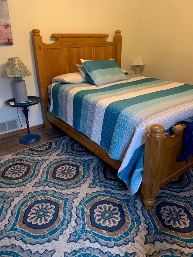 bedroom with visible vents and wood finished floors