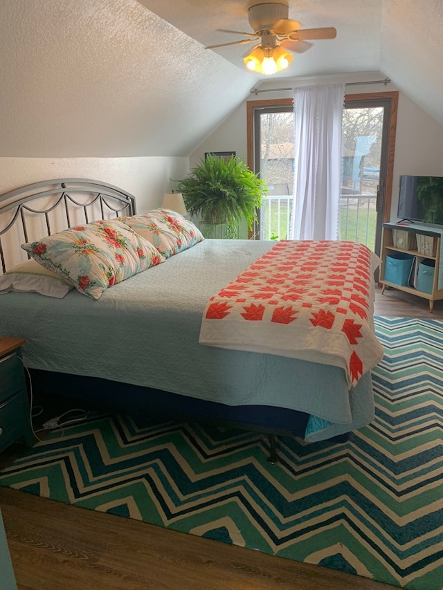 bedroom with a textured ceiling, access to outside, a ceiling fan, and vaulted ceiling