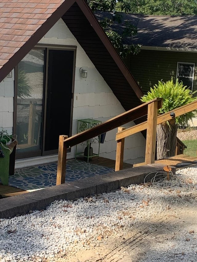 entrance to property featuring a shingled roof